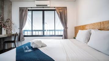 Una camera d'albergo con un letto, una scrivania e una finestra con tende.