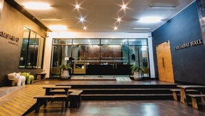A modern interior with a reception desk, glass doors, and a seating area with benches.