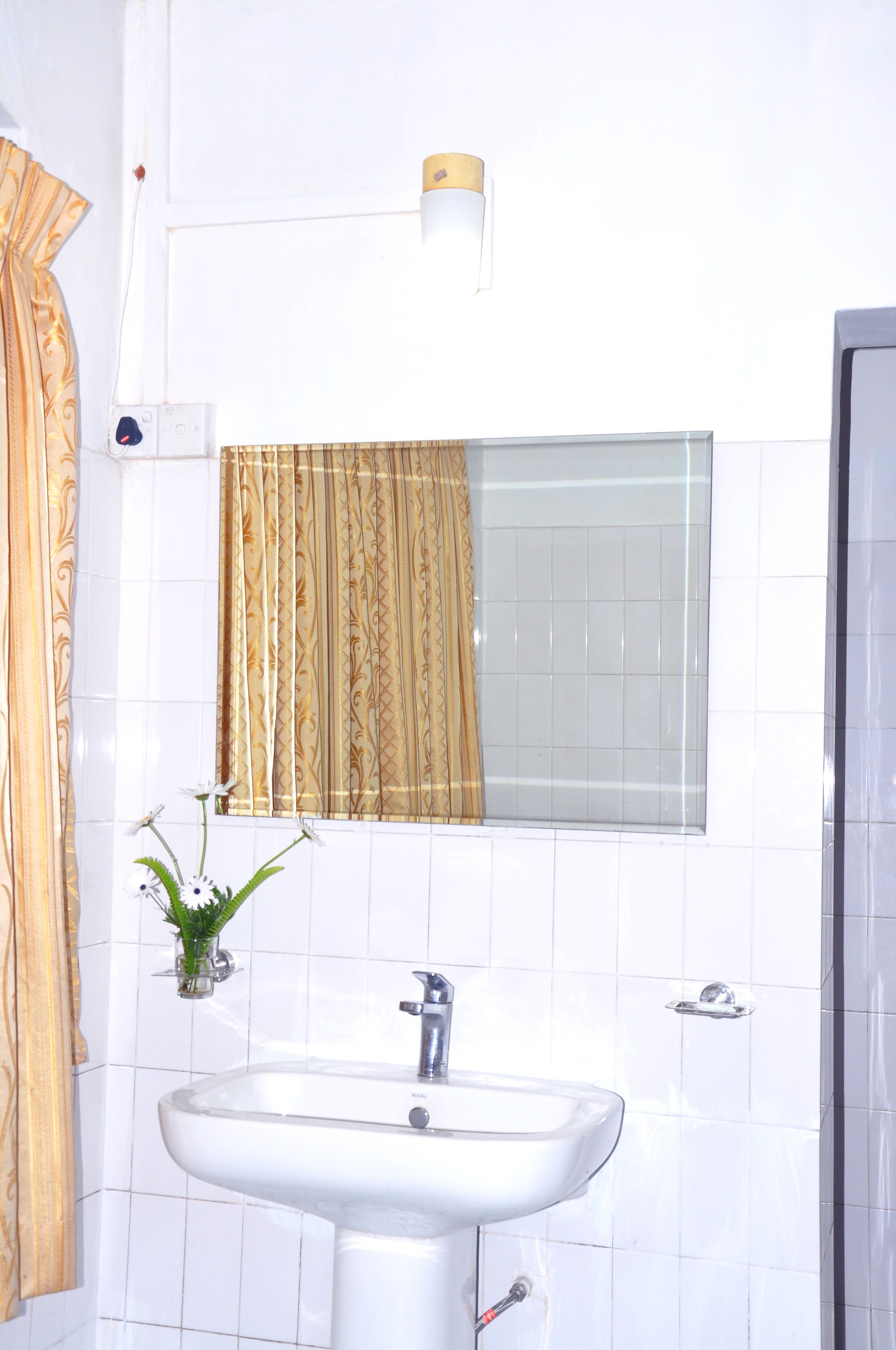 A bathroom with a white sink, a mirror, and a shower.