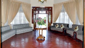 Amplia sala de estar con dos sofás, una mesa de centro de madera y un espejo decorativo.