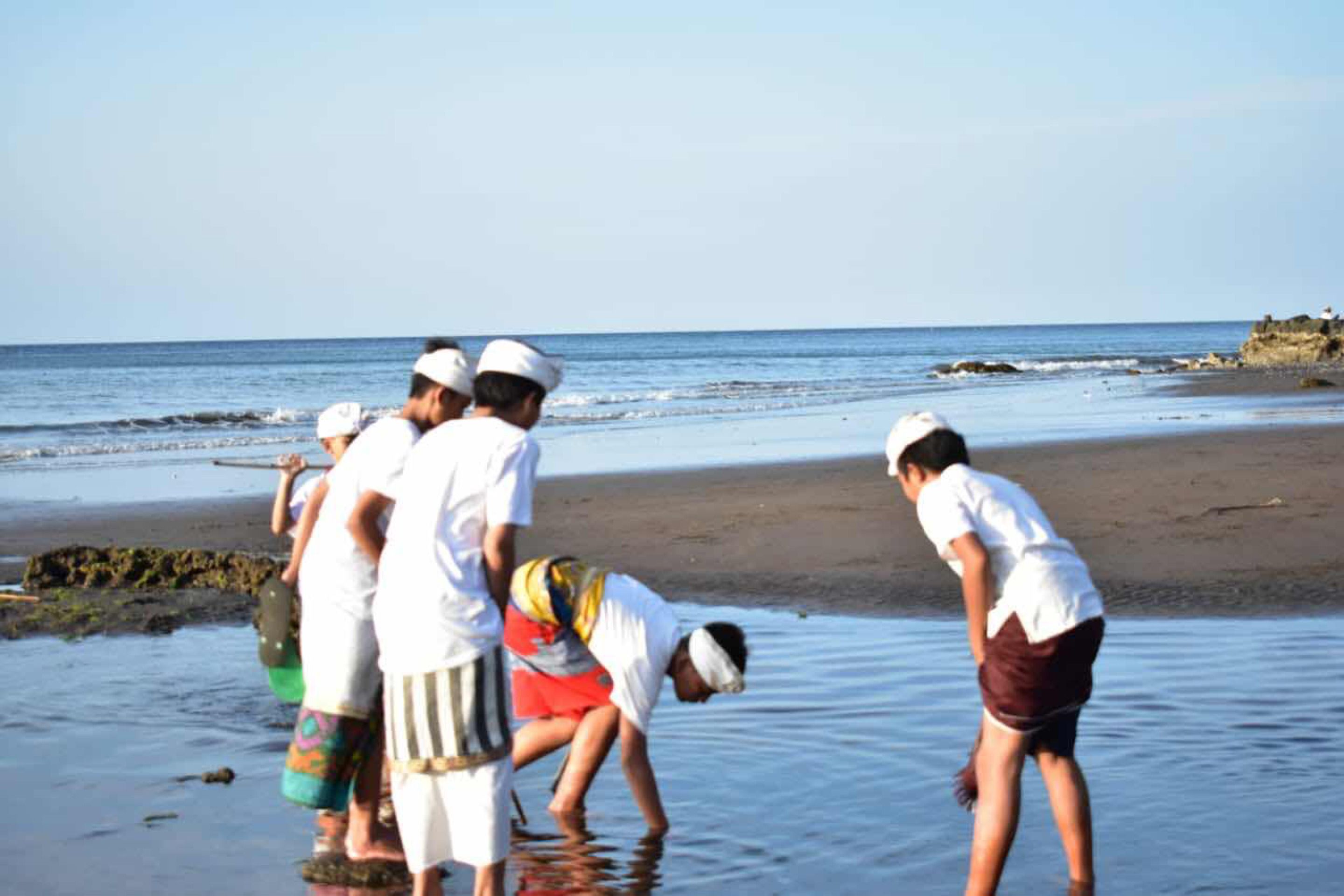 A group of people on a beach near the water.