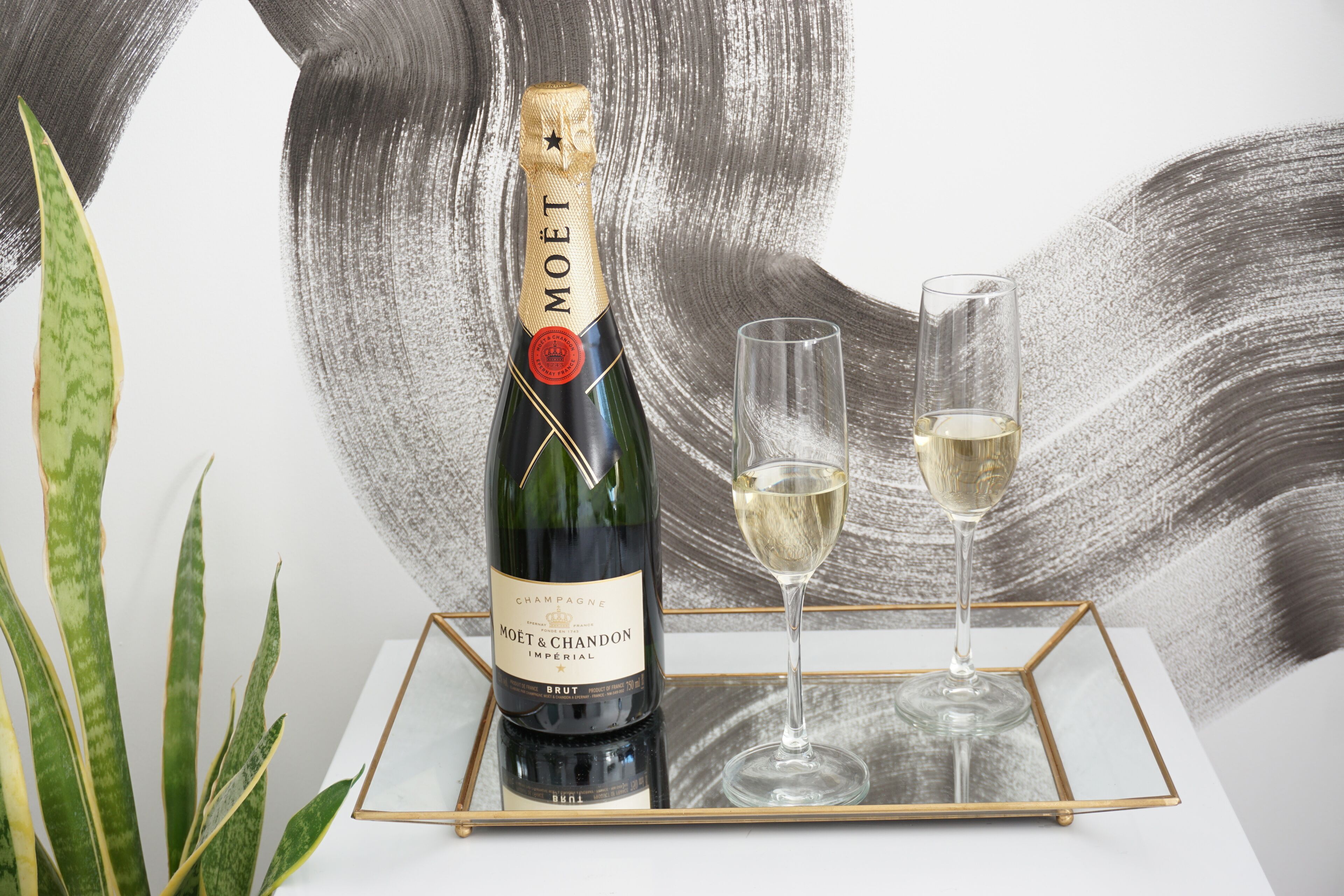 A bottle of Moët & Chandon Imperial champagne on a tray with two glasses.