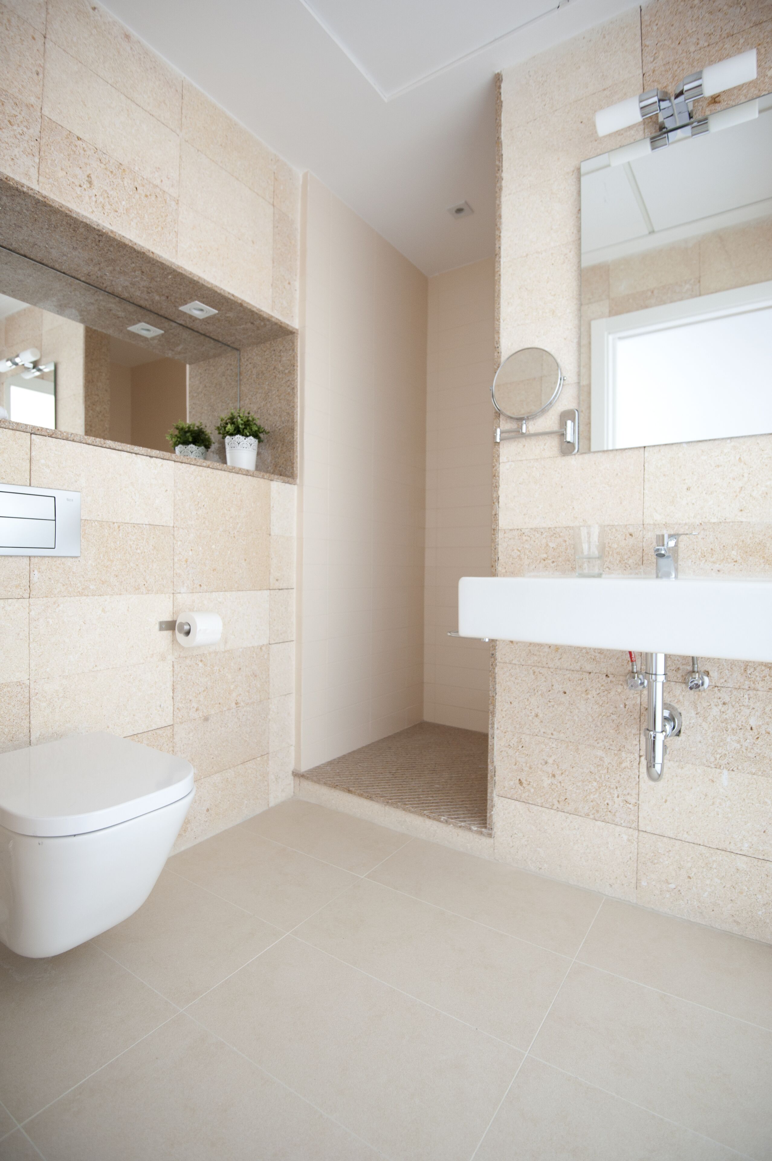 Un baño moderno con inodoro, lavamanos y ducha.