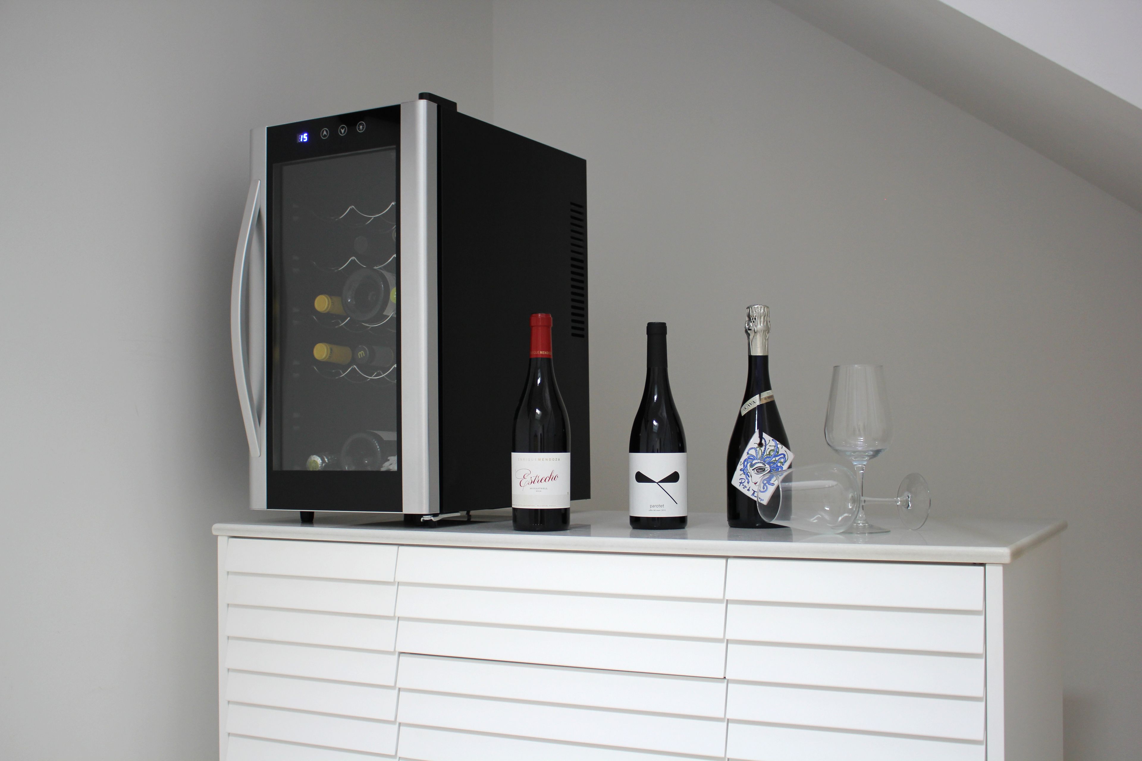 Un mini bar amb nevera i ampolles de vi.