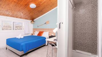 Una habitación con cama, escritorio, ducha y vistas al exterior.