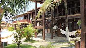 A courtyard with a pool, wooden balconies, and potted plants.