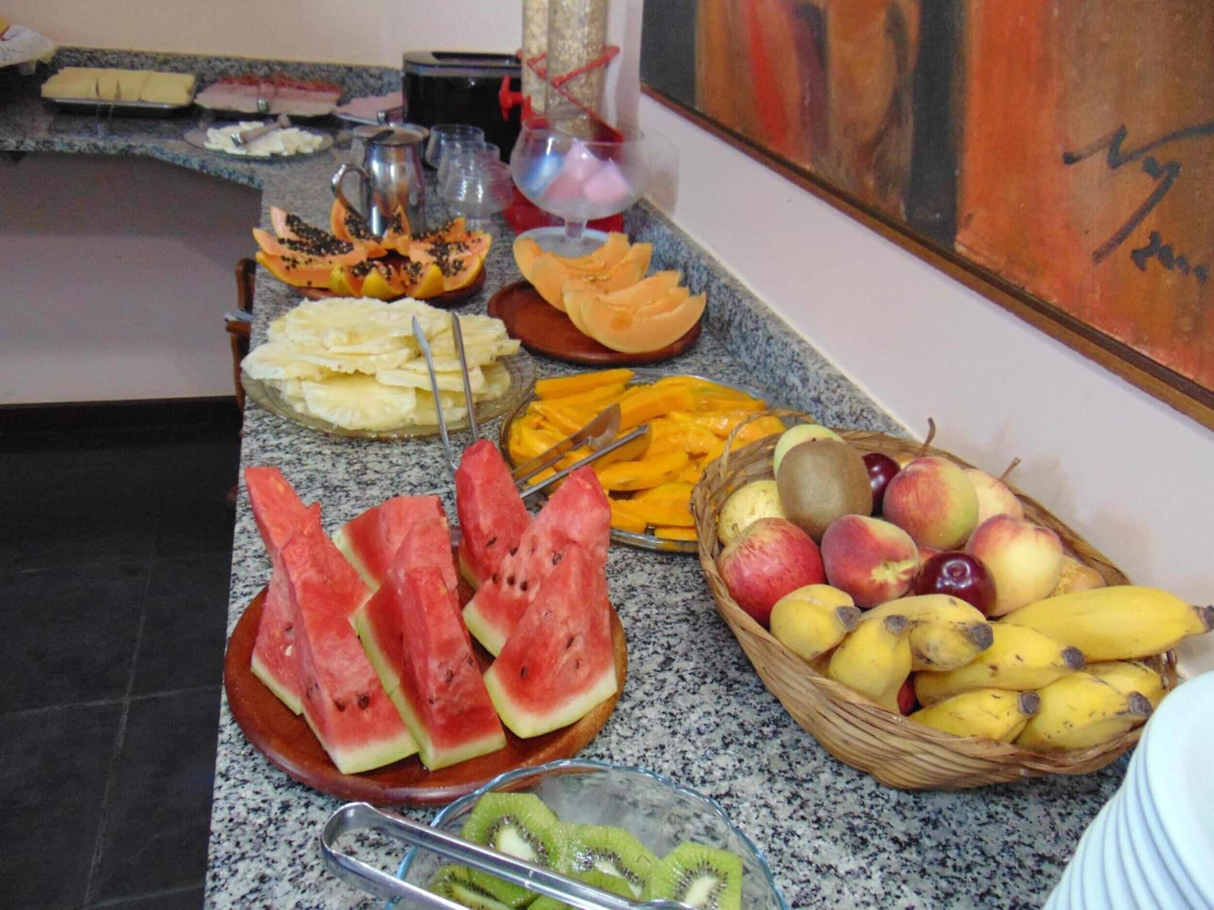 Ein Buffet mit verschiedenen Früchten und Gemüsesorten, darunter Wassermelone, Kiwis und Äpfel.