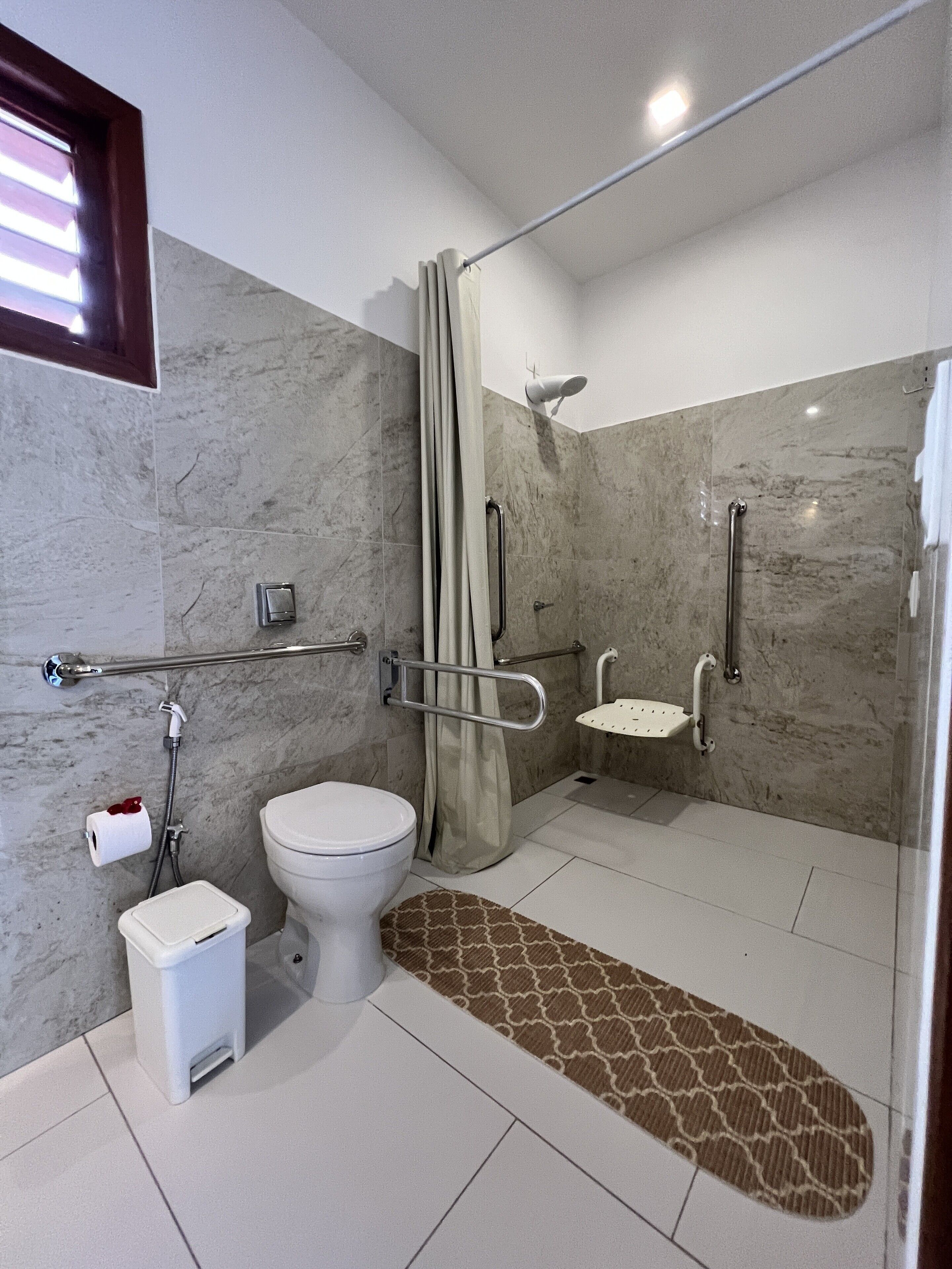 A modern bathroom with a toilet, bidet, and shower area.