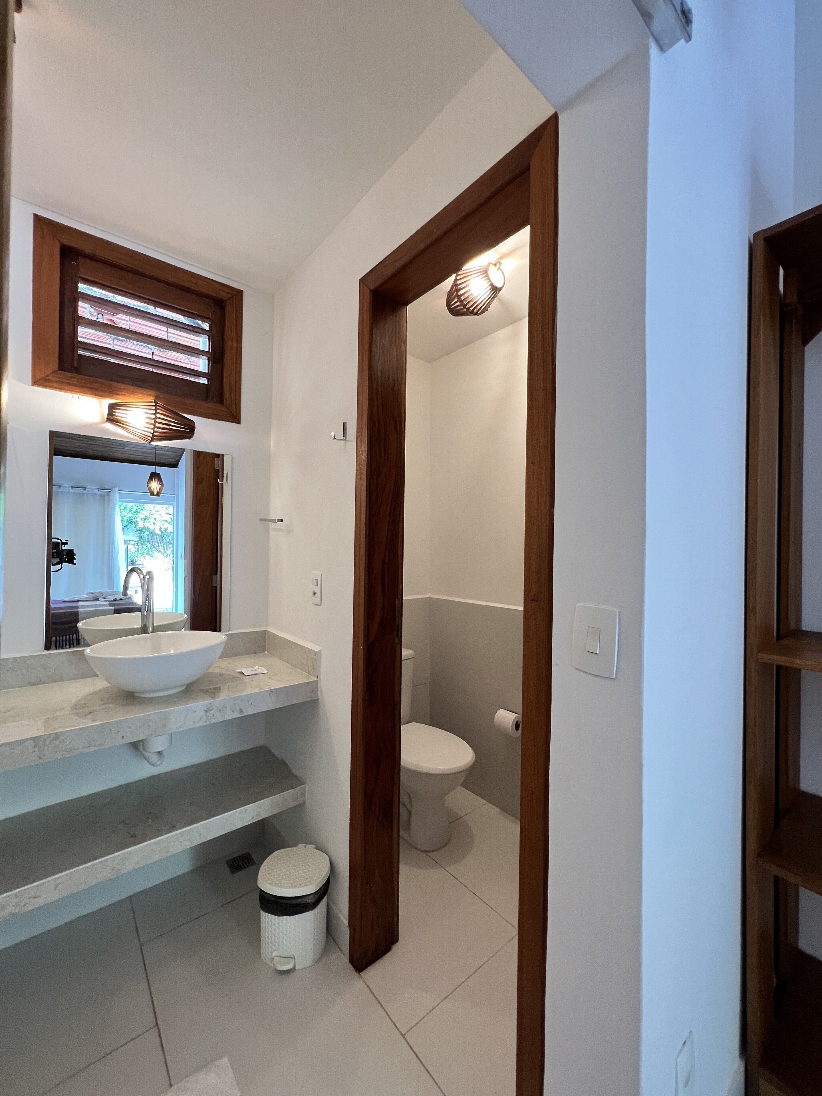 A bathroom with a white sink, a mirror, and a toilet.