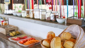 A buffet table with various food items and condiments. - Pousada Barbara (Tibau do Sul)