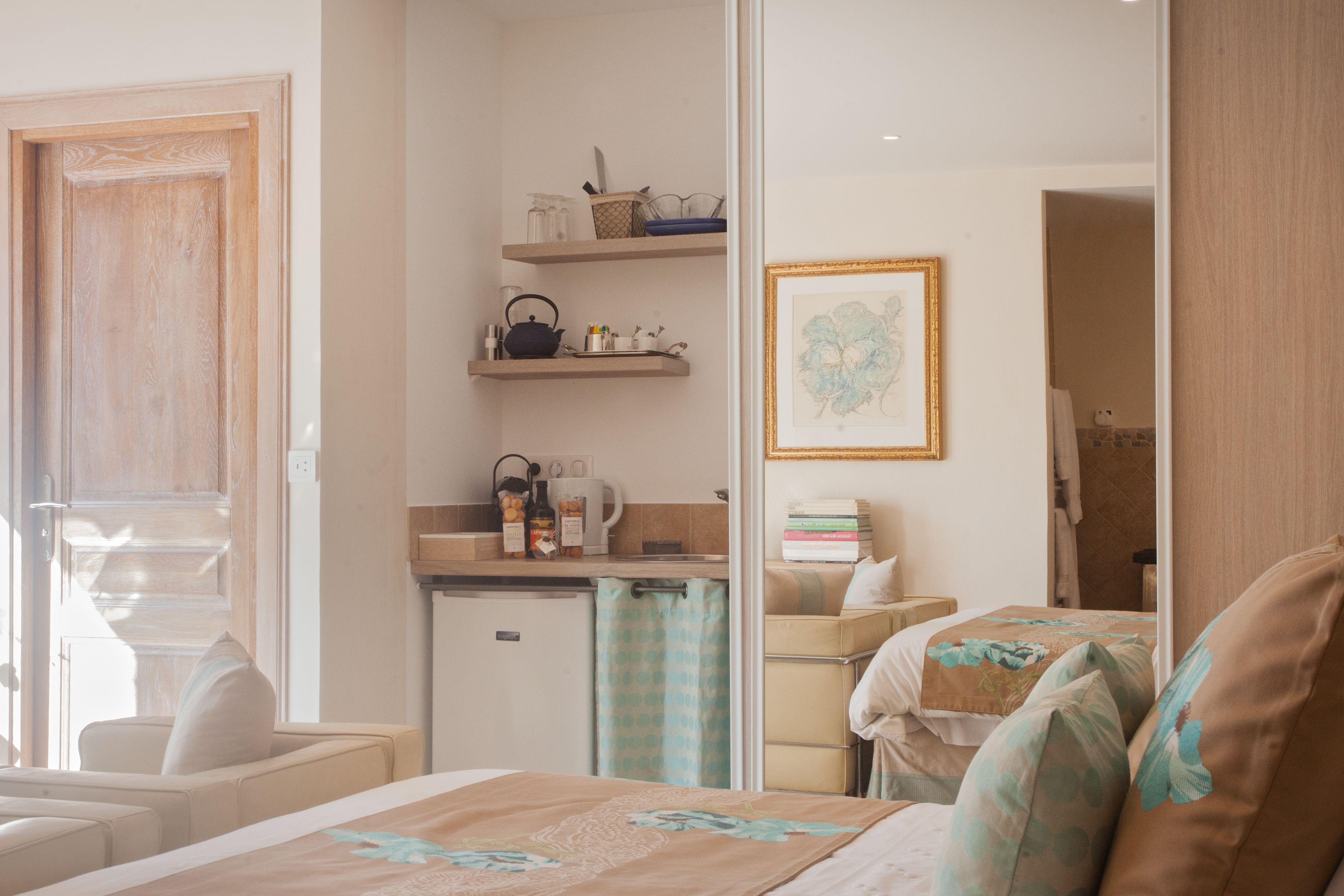 Habitación de hotel con cama, kitchenette pequeño, baño y vista al exterior.