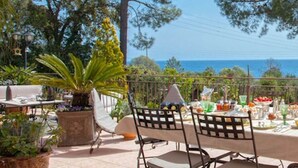 An outdoor dining area with a table set for breakfast, overlooking a scenic view of the sea. - Casa Del Sole Chambre d'hôtes de Charme (Sari-Solenzara)
