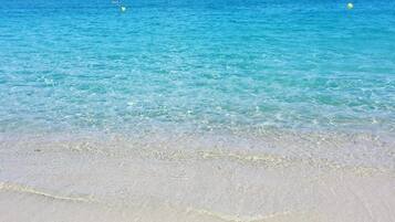 Una playa con aguas turquesas cristalinas y una orilla arenosa.