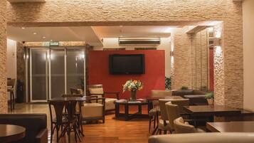 A lobby with a stone wall, a flat-screen TV mounted on the wall, and a reception desk.