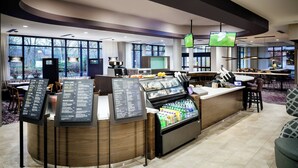A modern hotel lobby with a self-service beverage station, seating area, and large windows offering views of the outdoors. - Courtyard by Marriott Corvallis (Corvallis)