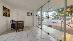 A room with a desk, chair, and a view through a glass door to the outside. - Piratas da Praia Fit Hostel (Recife)