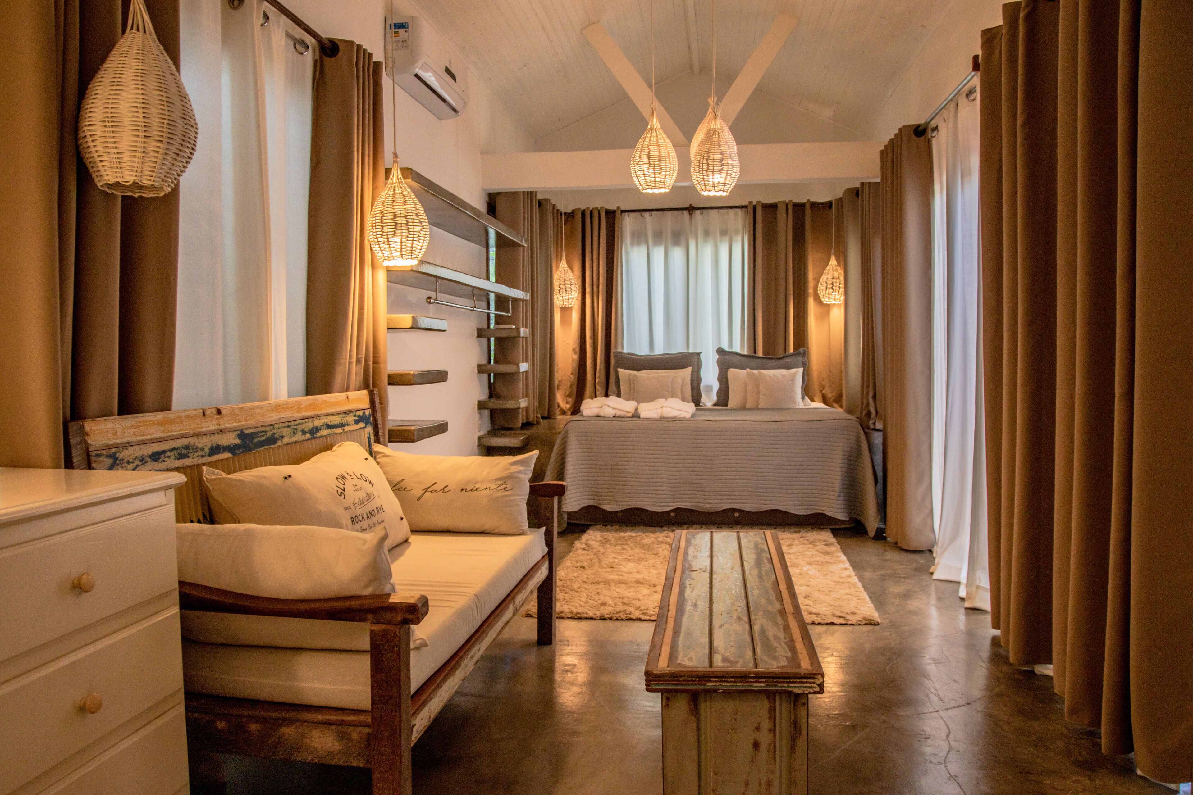 A bedroom with a bed, bedside tables, a dresser, and a wooden bench.