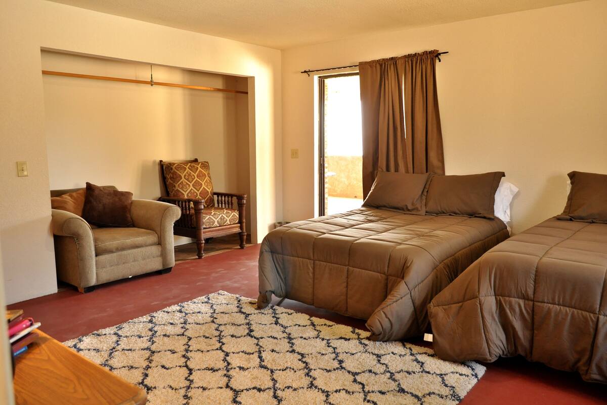 A bedroom with a bed, a chair, and a sofa.