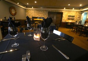 A dining table set with wine glasses, cutlery, and napkins. - Companion Hotel Motel (Hearst)