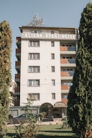 Un edificio de varios pisos con el letrero 'Asteria Apart Hotel' que indica que es un hotel.
