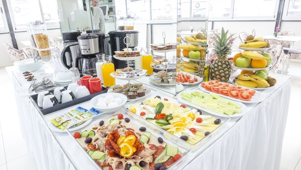 A buffet with various food items including fruits, vegetables, and deli slices. - Astera Apart Hotel (Skopje)