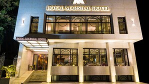 L’extérieur du Royal Marshall Hotel se distingue par sa façade moderne, ses grandes fenêtres et son entrée imposante.