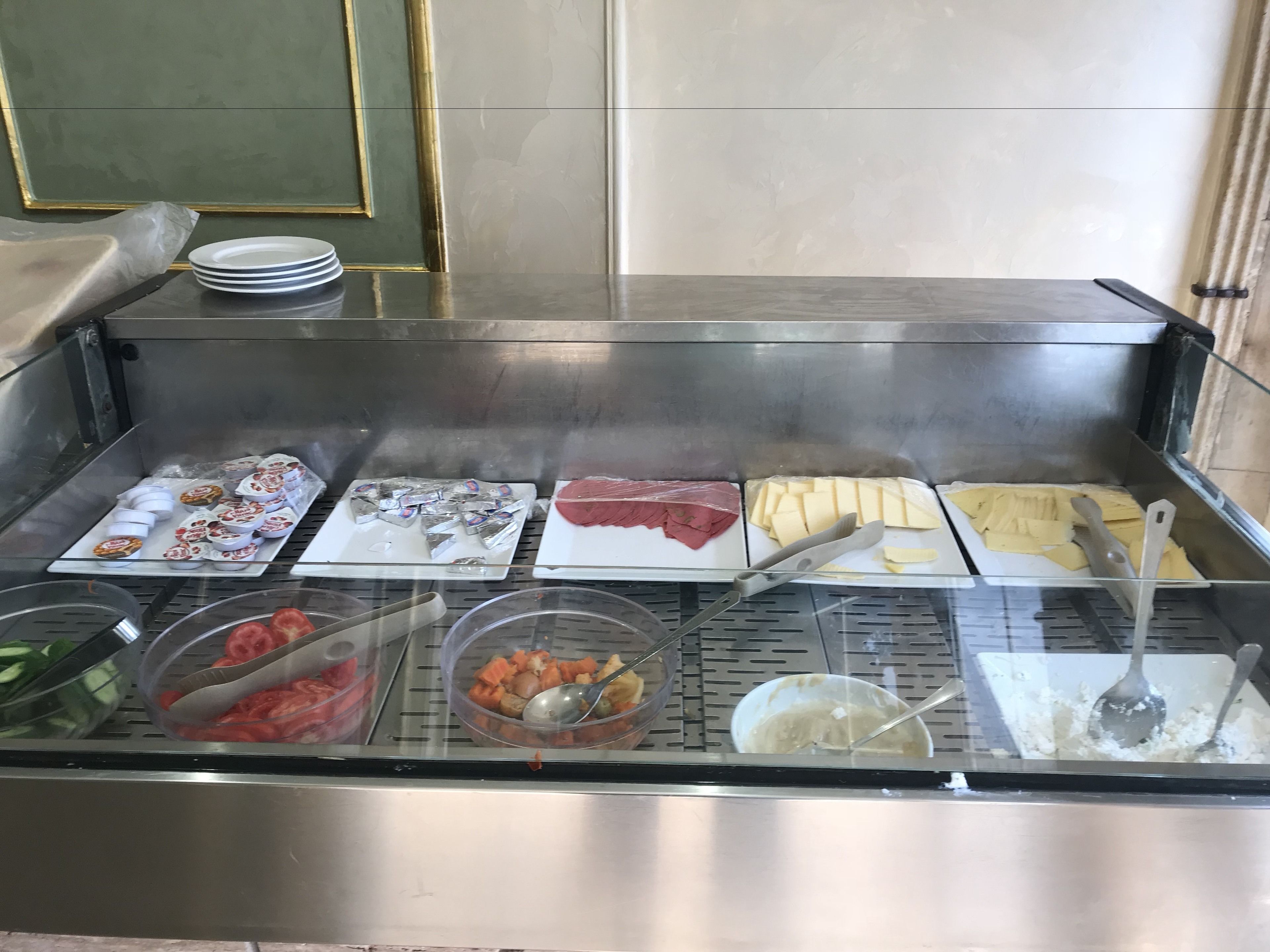 Un bufé con diversas opciones de comida, incluyendo carne, queso y verduras.