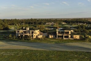 A residential area with modern houses, a golf course, and a body of water. - Cygnature Boutique Lodge (Modderrivier)