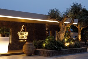 A stone building with a neon sign reading "SIRENE BLUE". - Sirene Blue Resort (Poros)