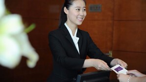 Ein Hotel-Empfangsbereich mit einer Rezeptionistin.