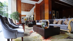 Eine großzügige Lobby mit einer großen Couch, Sesseln und einem Couchtisch.