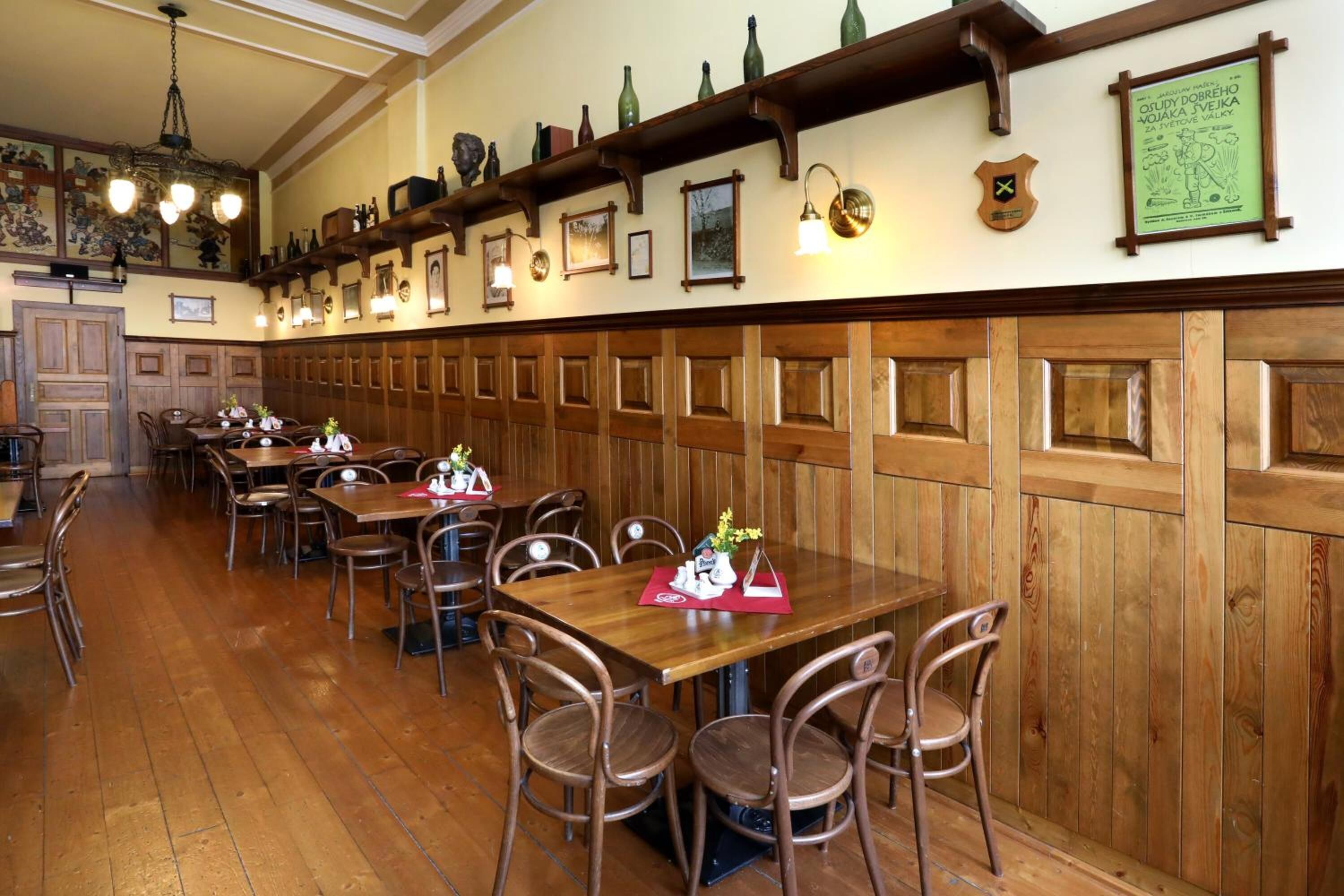 Ein Restaurant mit Holzwandverkleidung, mehreren Tischen und Stühlen.