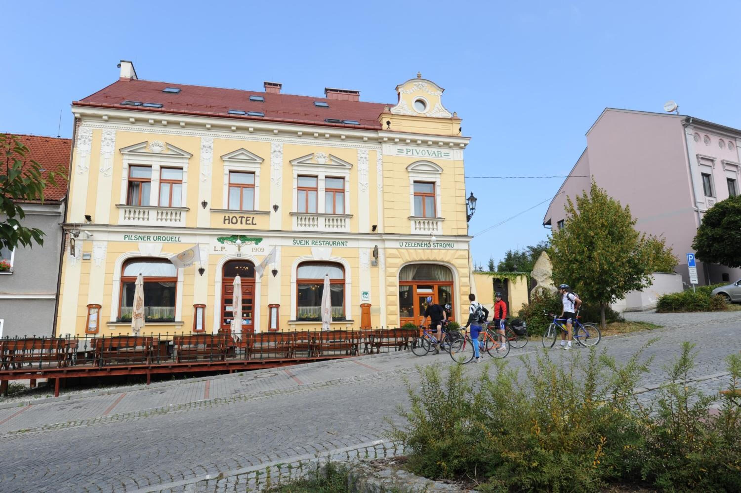 A historic building with a sign for 'Pilsner Urquell Hotel' and 'Sujeik Restaurant'.