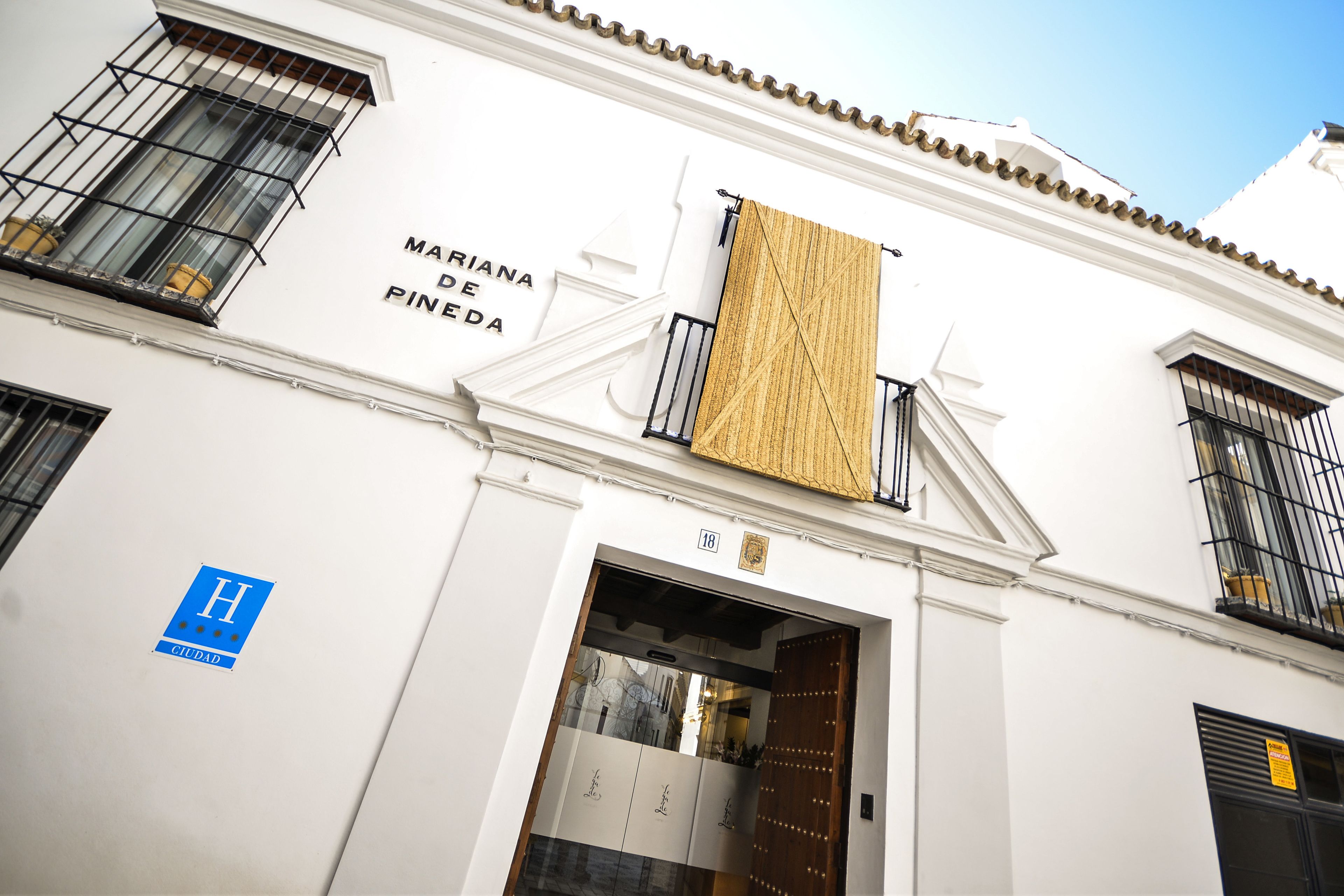 A building with a sign reading "MARINA DE PINEDA" and a blue "H" sign indicating a hotel.