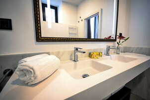 A bathroom with a double sink, a large mirror, and a towel on the side.