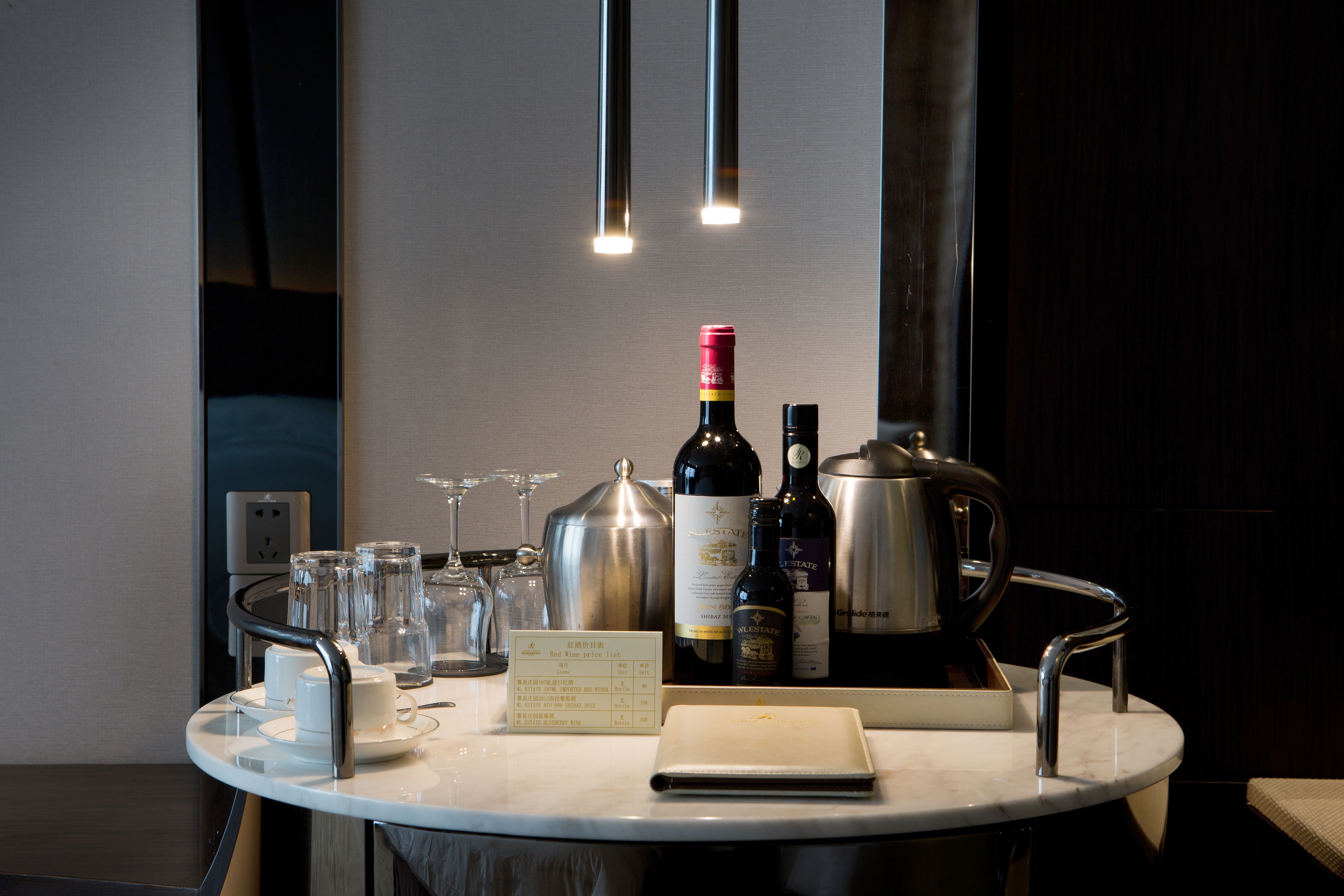 A table with a wine bottle, glasses, and a menu in a modern setting.