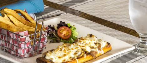 A meal consisting of a sandwich, fries, and a salad on a table with a placemat.