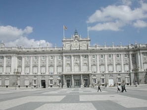 Un edificio grande e histórico con fachada simétrica, ventanas amplias y una entrada central.