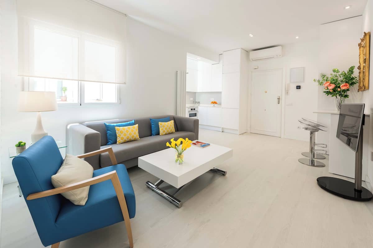 Ein modernes Wohnzimmer mit einer Couch, einem Couchtisch und einem blauen Sessel.