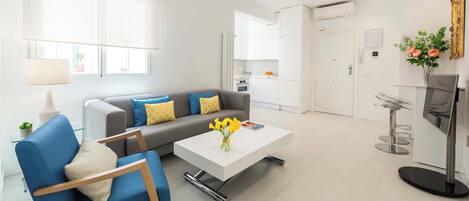 Ein modernes Wohnzimmer mit einer Couch, einem Couchtisch und einem blauen Sessel.