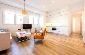 Deluxe-Apartment, 3 Schlafzimmer, barrierefrei, Küche | Wohnzimmer | Fernseher, Bücher