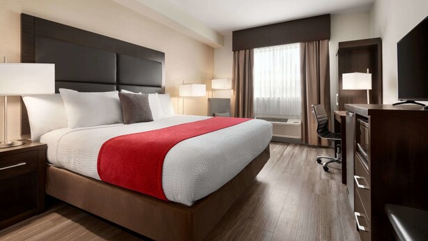 Une chambre d’hôtel avec un grand lit, un bureau et une télévision.