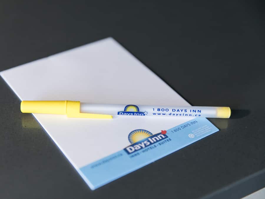 A Days Inn business card with a yellow pen on top.