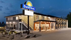 Un hôtel Days Inn au design moderne, avec une enseigne bien visible, un escalier et une entrée bien éclairée.