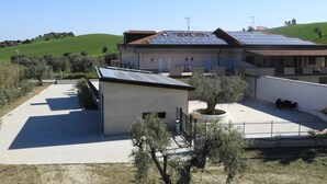 Un bâtiment moderne doté d’un toit plat, de panneaux solaires et d’une petite structure adjacente.