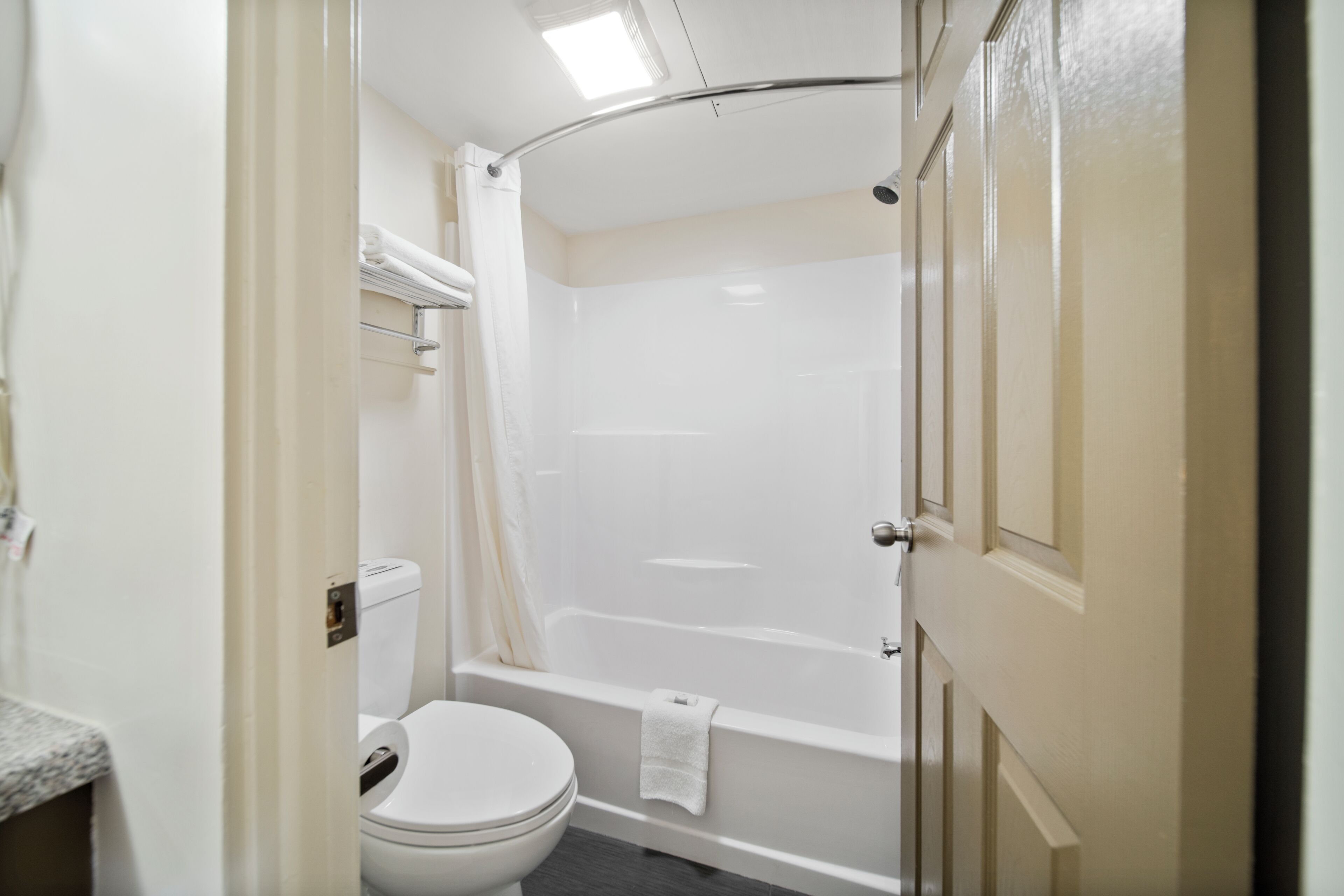 Un baño con inodoro, bañera y cortina de ducha.