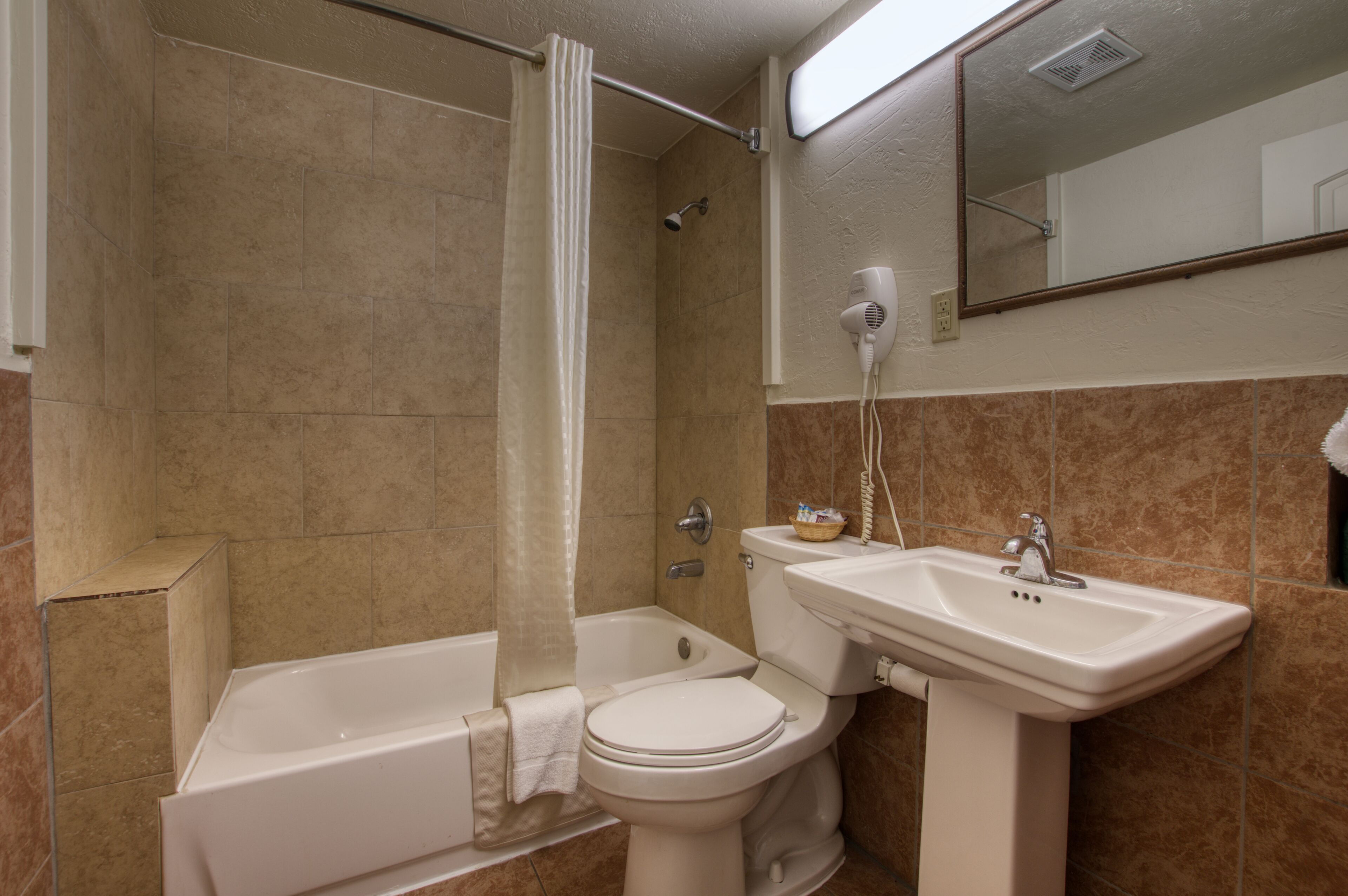 A bathroom with a bathtub, toilet, and sink.