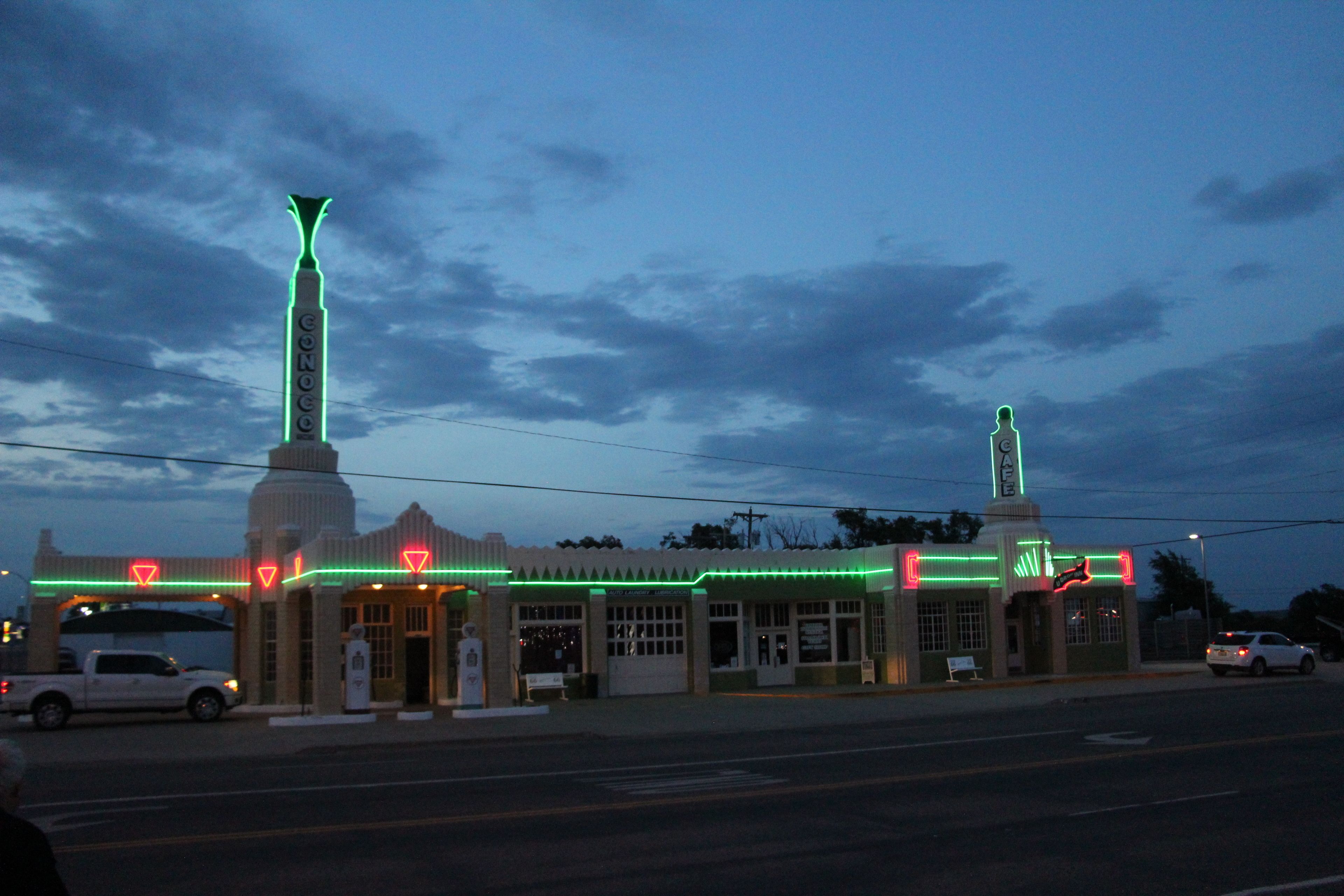 A building with a prominent tower and a smaller structure with neon lights.
