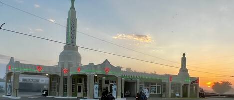 A gas station with a tall, narrow building and a smaller structure with a sign.