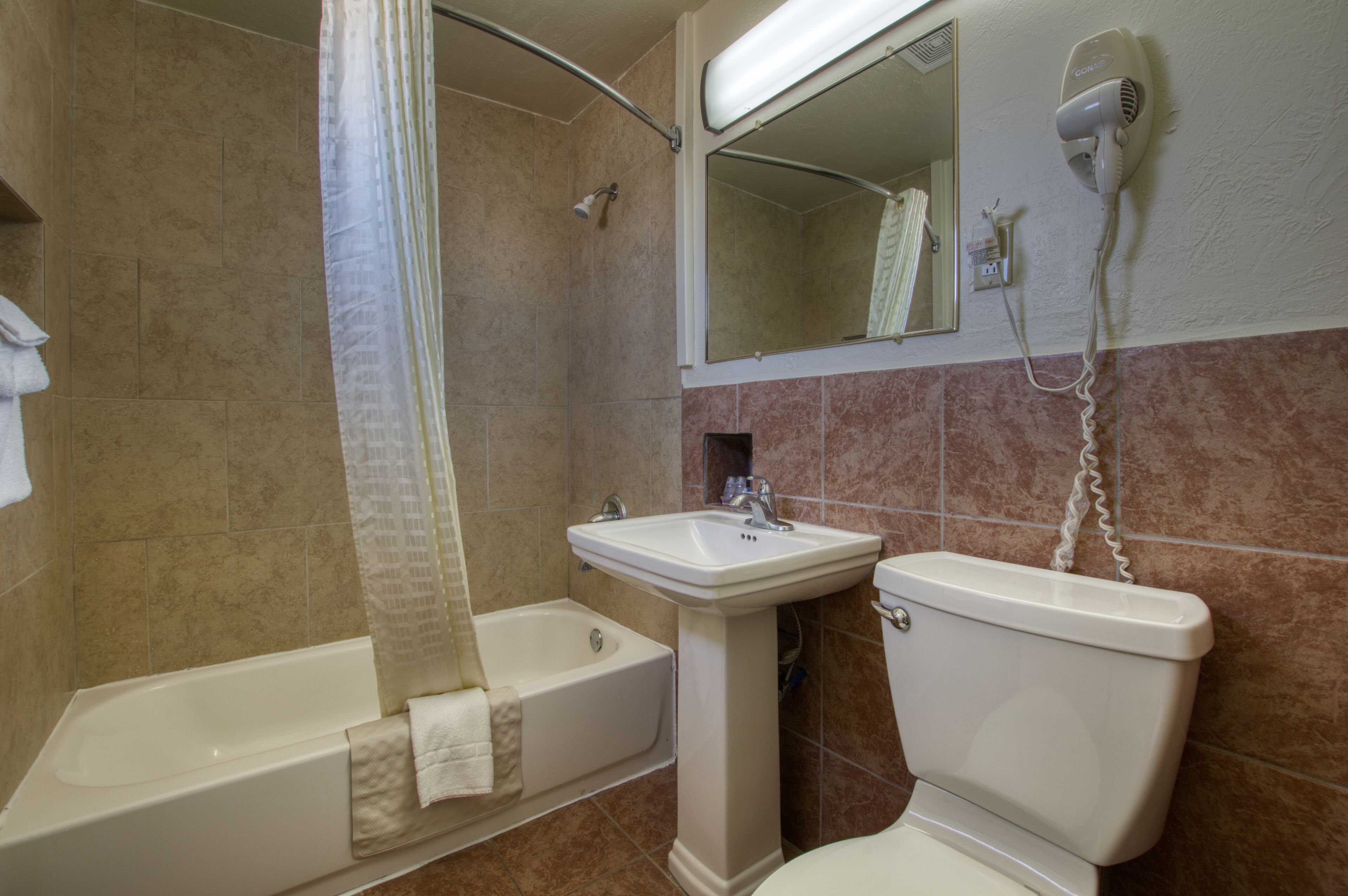 Un baño con bañera, lavabo e inodoro.